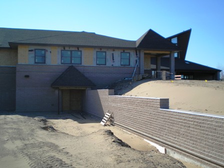 picture taken from front elevation, looking up at Church Addition at lower level beside parking lot retaining wall