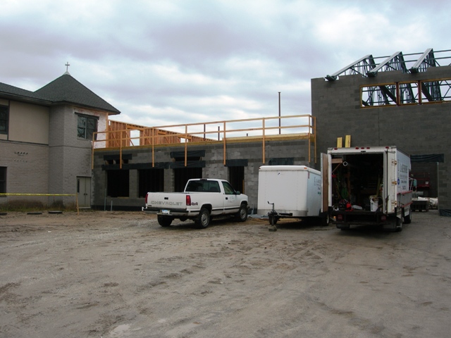 picture of addition under construction at the rear elevation - second floor framing and steel roof trusses are being installed