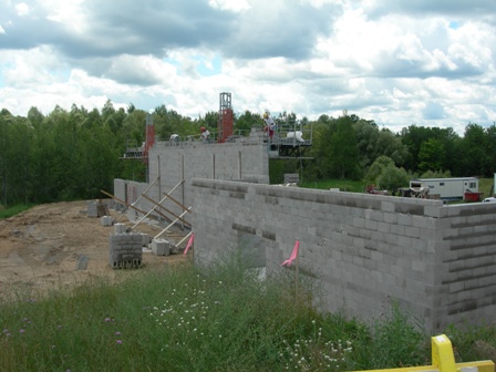 photo of wall construction at Word of Life Church in Alpena - scaffolding and wall supports are visible, as well as work platforms for upper walls being built - view from parking lot at the front of the Church