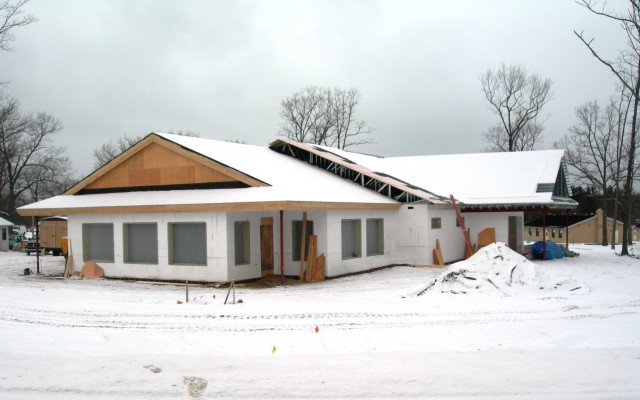 picture of dining hall with exterior walls erected, roof structure is on and covered with snow