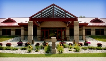 exterior picture of Main Entry to Collins Center - Training Facility at Alpena Combat Readiness Training Center - decorative concrete masonry unit construction with red metal roof and trim