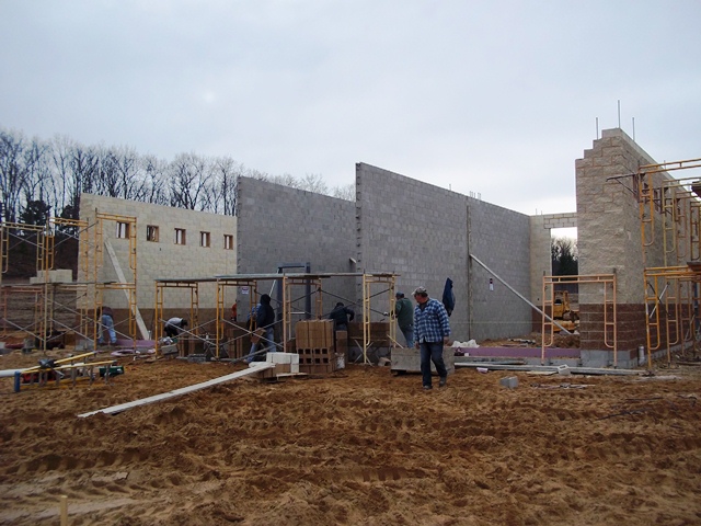 workmen erecting concrete masonry walls