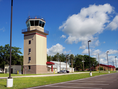 picture of Air Traffic Conrol Tower at Alpena CRTC in the foreground with Squadron Operations building down the road - photo of control tower is looking toward the 'rear' elevation and side elevation that faces the airfield runways