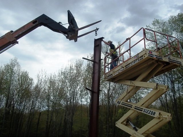 picture of man on Sizzor Lift installing metal building column