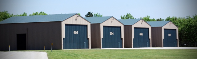 picture of Hangars at Alpena Combat Readiness Training Center - painted tan with dark blue doors