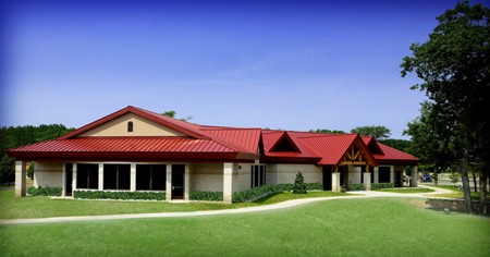 exterior picture of Dining Hall at Alpena Combat Readiness Training Center - light tan masonry wall construction and red metal roof