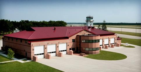 picture of a 22,000 SF state-of-the-art facility designed to provide fire protection to the structures on the base, and crash-rescue response to the airfield.  The building has 12 bays, accommodations for 20 full time personnel, along with a full time alarm room, day room, living quarters, training and conference spaces, and administrative offices.