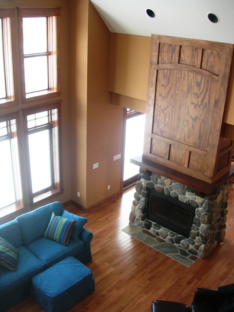 picture of interior looking down at fireplace from second floor stair landing