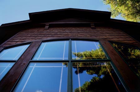 picture of golf course home - this exterior photo was taken while standing on the outdoor deck, looking straight up the window wall toward the roof peak - taking every opportunity for customizing a home's design