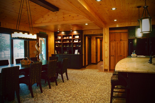 interior photo of dining room with wood plank ceiling and walls, custom light fixtures and pebble-stone mosaic floor