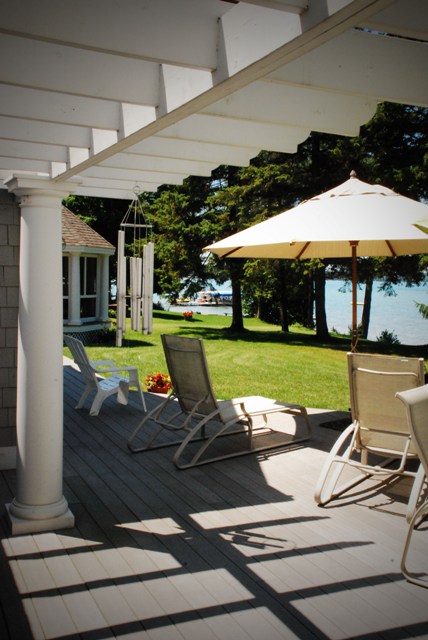 picture of Torch Lake from deck, pergola, deck chairs and umbrella