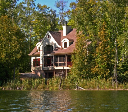 picture of waterfront home on Twin Lakes in Cheboygan, Michigan - this exterior photo was taken from out on the water of Twin Lakes - the home is nestled in the trees on the lake shore