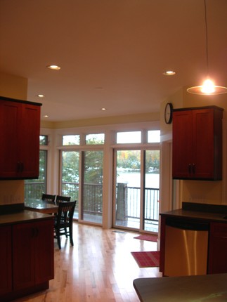 picture of waterfront home on Twin Lakes in Cheboygan, Michigan - this interior photo was taken from one end of the kitchen, looking toward the dining area and out the sliding glass doors to the outdoor deck on the lake side of the home