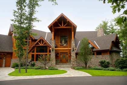 Exterior photo of road-side elevation Ward Lake Residence, Gaylord, Michigan - picture taken in early summer of main entry showcasing the home's timber and stone construction