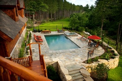 picture of the swimming pool, spa and seating areas from the top of the stairs at the second level deck - Ward Lake Residence, Gaylord, Michigan