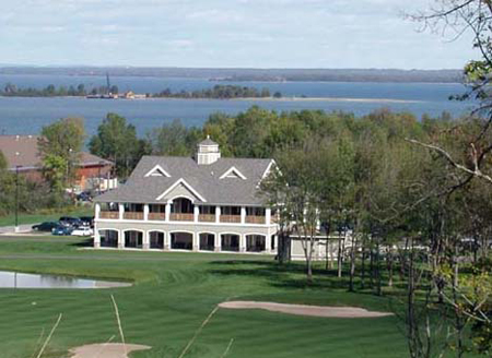 exterior picture of Wild Bluff Golf Course Clubhouse, taken from the top of a hill on the course, with view of Lake Superior in the background